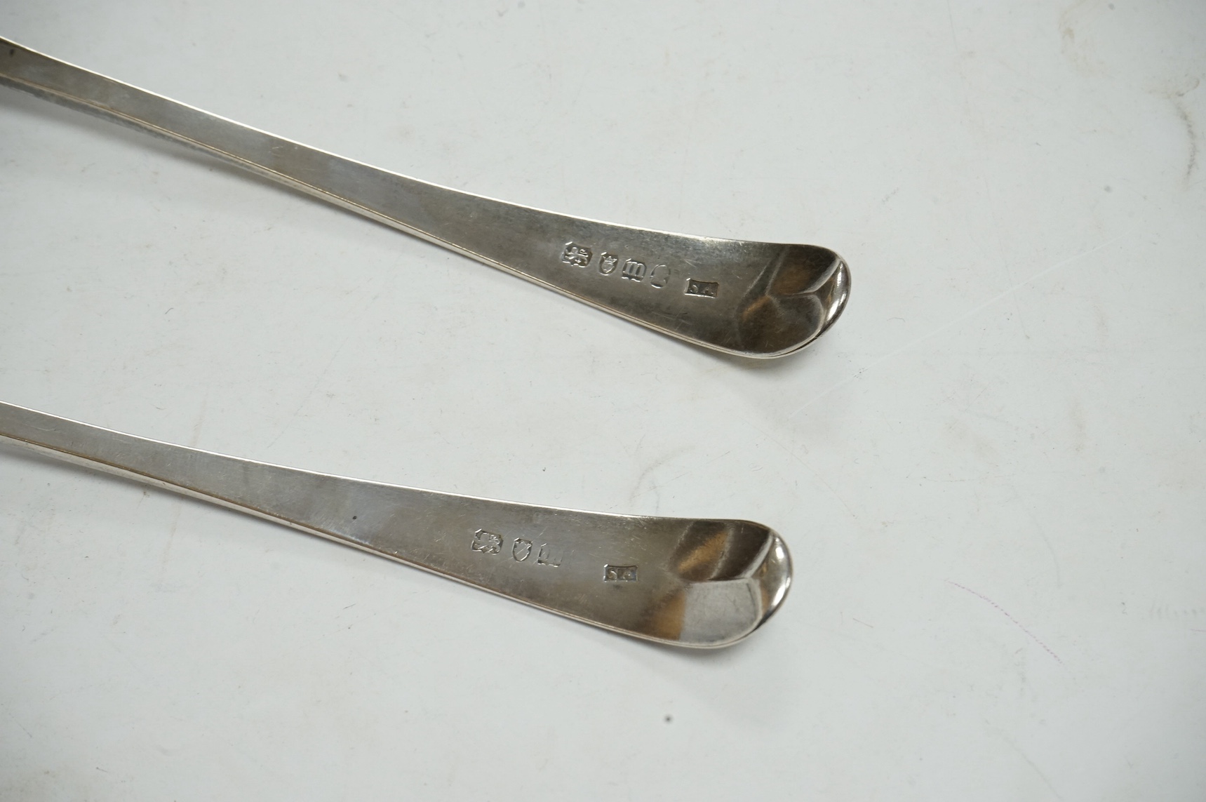 A pair of George III silver bright cut engraved Old English pattern table spoons, Stephen Adams II, London, 1787, 21.5cm. Condition - poor to fair